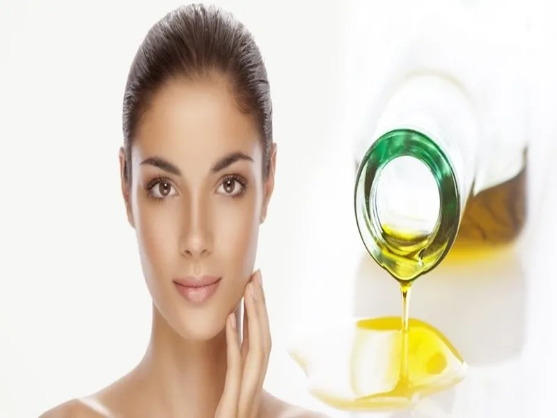 Olio extravergine di oliva versato accanto a un ramoscello, usato come rimedio naturale per la pelle