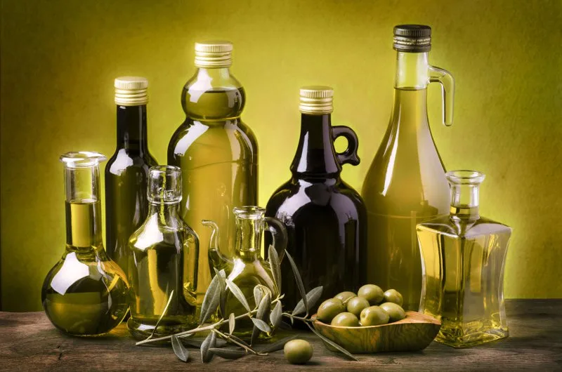 Bottiglie e brocca di olio extravergine di oliva pugliese appena spremuto