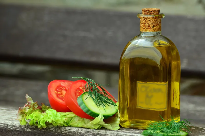 Un filo d'olio extravergine d'oliva versato, simbolo dei valori nutrizionali e delle calorie dell'EVO